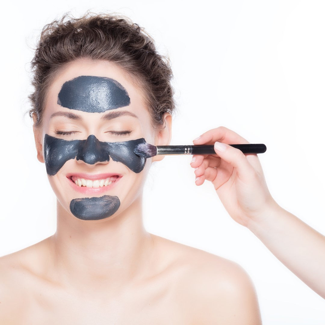 Woman putting on charcoal face wash